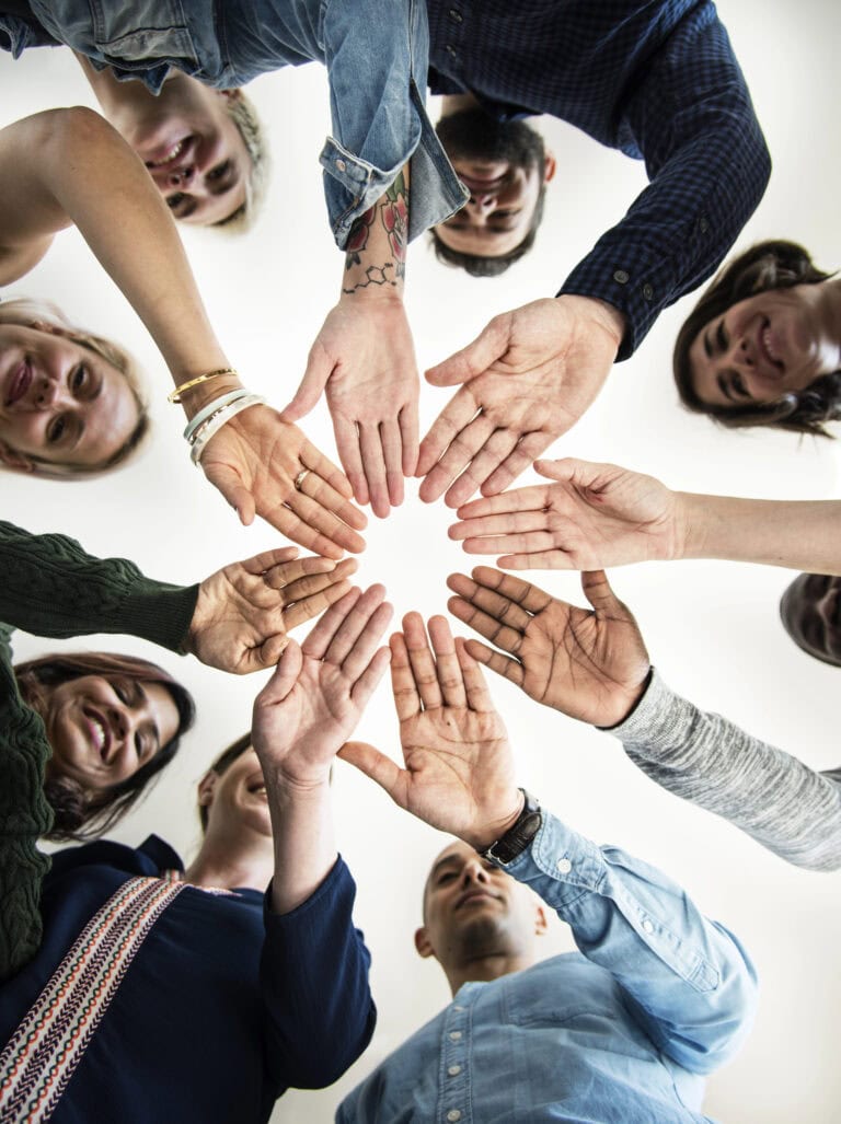 Diverse people in a circle holding hands straight and making a circle shape with the gap