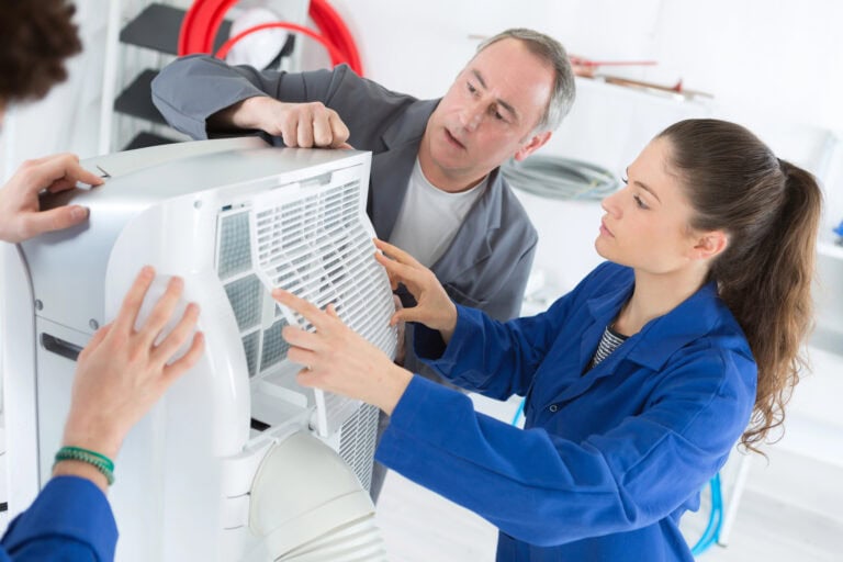 HVAC students working on an air conditioning unit