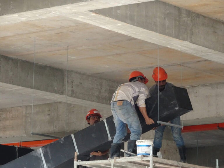 HVAC workers install pipe system for ventilation and air conditioning.